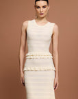 Woman wearing a Sandro sleeveless, tiered dress with a beige and white layered knit maxi dress