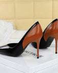 Black and brown high-heeled shoes on a white surface with a blurred background