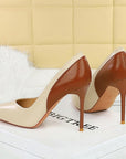 Pair of high-heeled shoes with beige and brown design on a white surface.