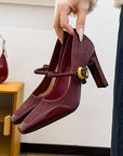 Maroon high-heeled Mary Jane sandals with a gold buckle