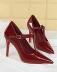 Red patent-look T-strap pointed-toe stiletto heels with 10 cm heel and buckle strap