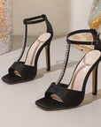 Black high-heeled sandals with rhinestone straps
