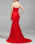 Woman wearing a strapless red evening gown on a gray background