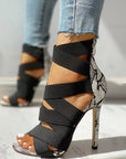 Black strappy high-heeled shoes with snake print