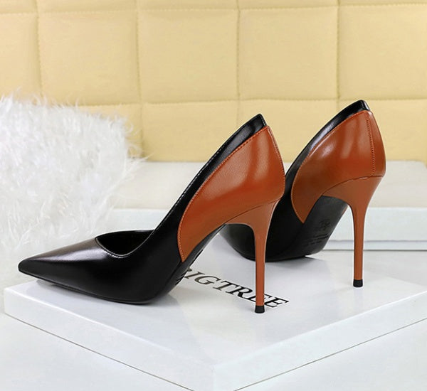 Black and brown high-heeled shoes on a white surface with a blurred background