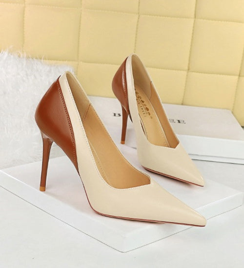 Pair of high-heeled shoes with brown and beige color scheme on a white surface.