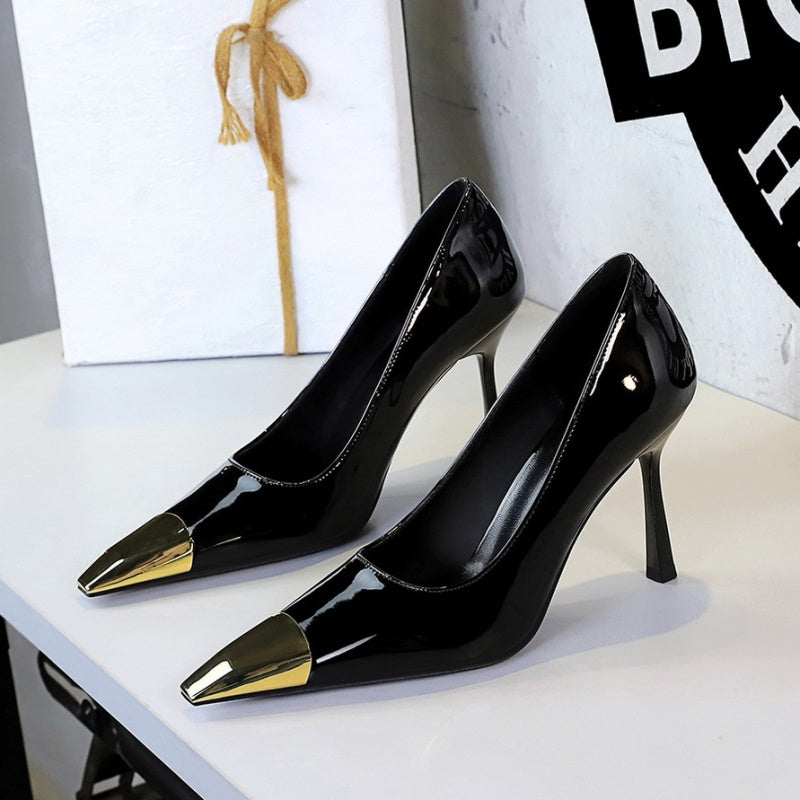 Black high-heeled shoes with gold metal accents 