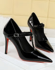 Black patent-look T-strap pointed-toe stiletto heels with 10 cm heel and buckle strap