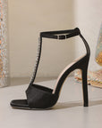 Black high-heeled sandals with rhinestone straps 