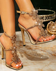 Gold high-heeled sandals with floral designs