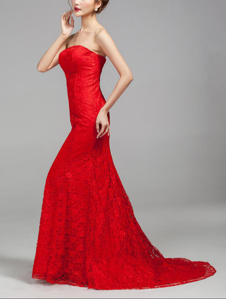 Woman wearing a red strapless gown on a gray background