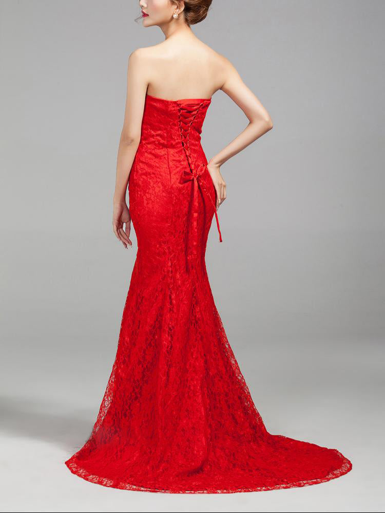 Woman wearing a strapless red evening gown on a gray background